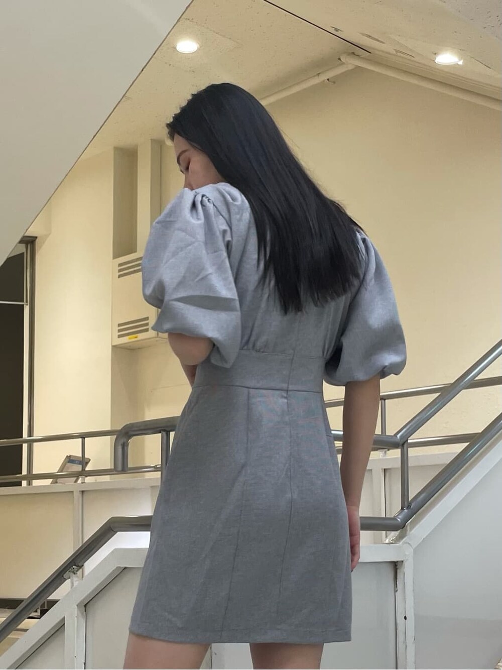 グレー系のワンピース、ゴールド系のピアス(両耳用)を着用したレディースの夏コーディネートの3枚目の写真