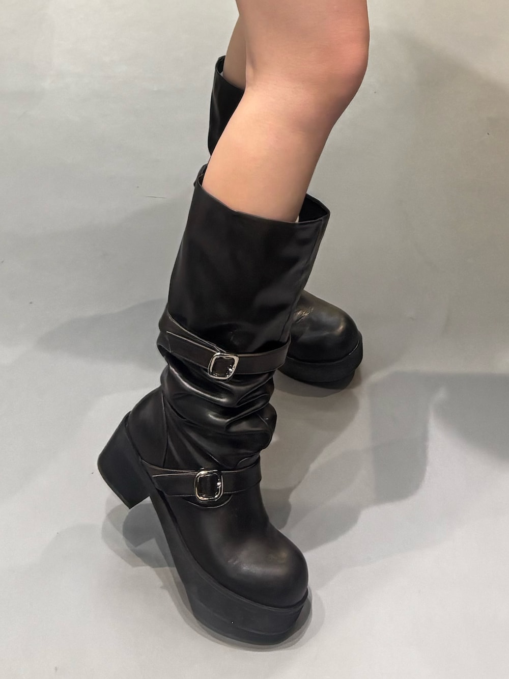 ブラック系のブーツ、ブラック系のスカート、ブラック系のパーカーを着用したレディースの冬コーディネートの5枚目の写真