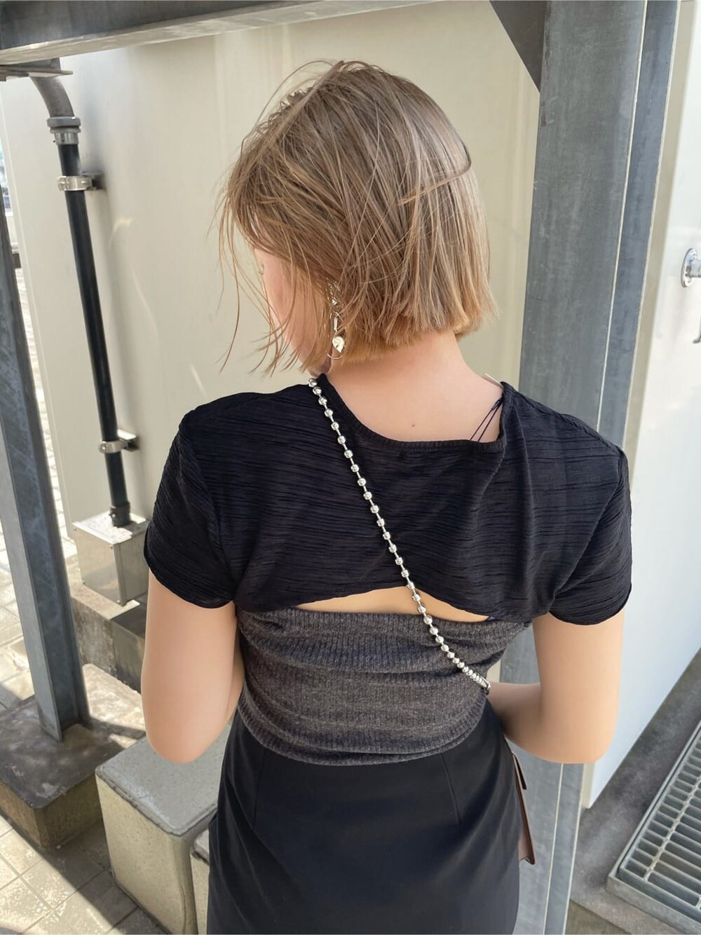 ブラウン系のハンドバッグ、ブラック系のサンダル、ブラック系のスカートを着用したレディースの夏コーディネートの4枚目の写真