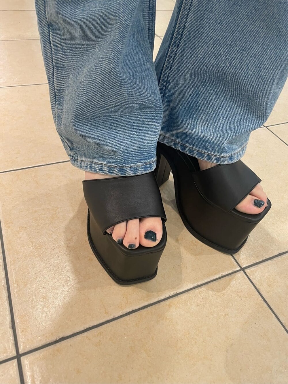 ブラック系のサンダル、ホワイト系のシャツ/ブラウス、ブルー系のデニムパンツを着用したレディースの春コーディネートの7枚目の写真