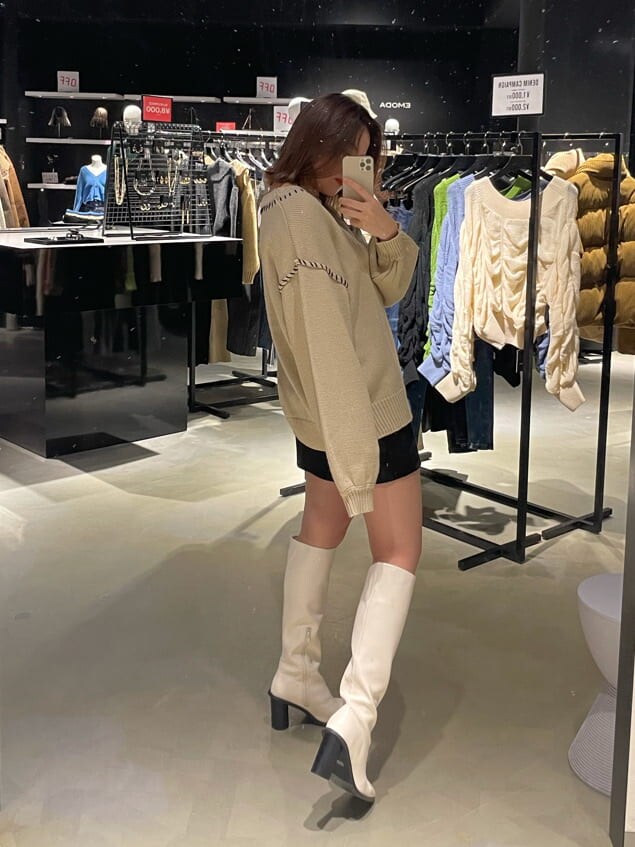 ブラック系のブルゾン、ホワイト系のブーツ、ホワイト系のニット/セーターを着用したレディースの冬コーディネートの3枚目の写真