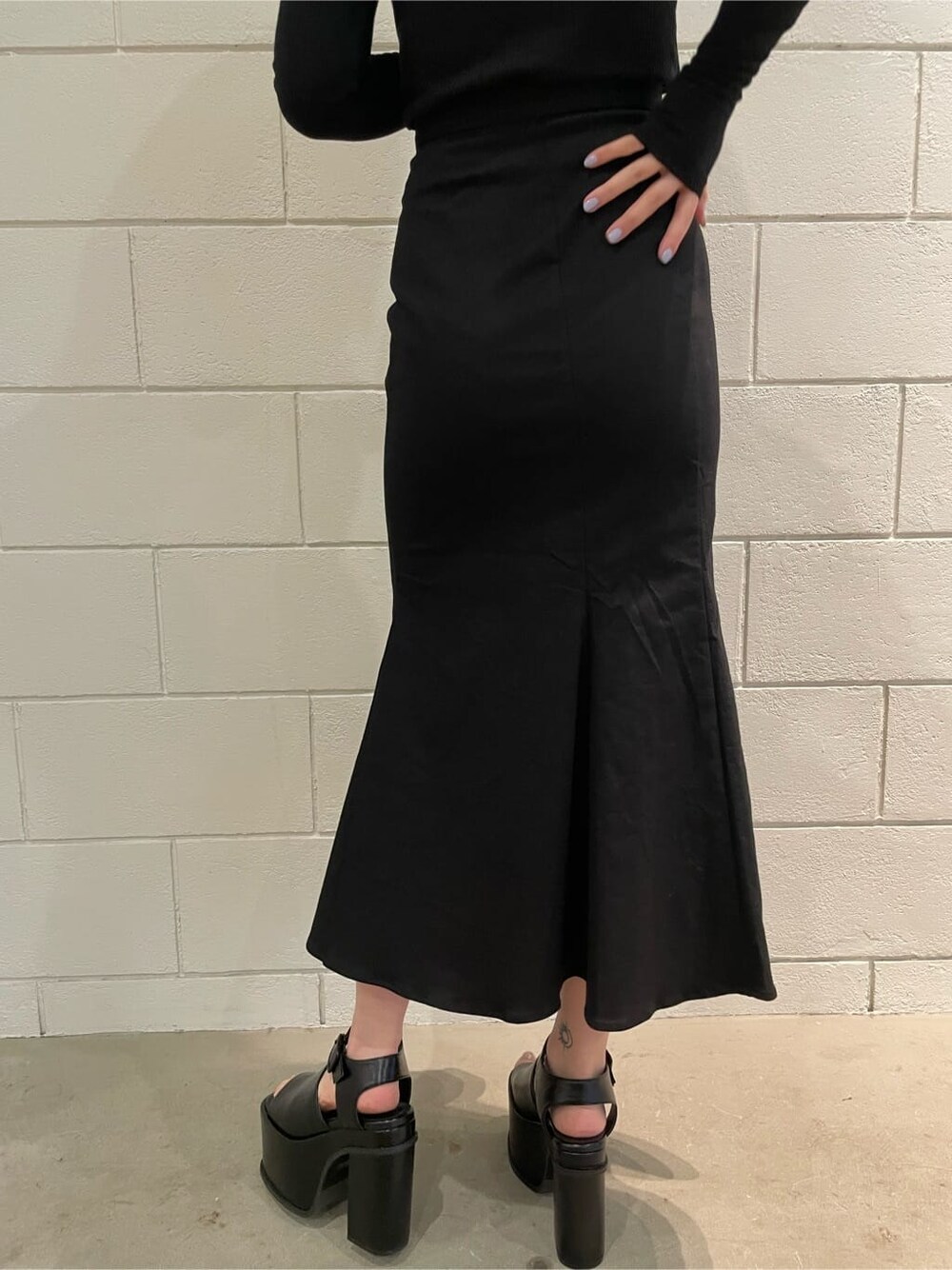 ブラック系のサンダル、ブラック系のスカート、ブラック系のTシャツ/カットソーを着用したレディースの春コーディネートの7枚目の写真