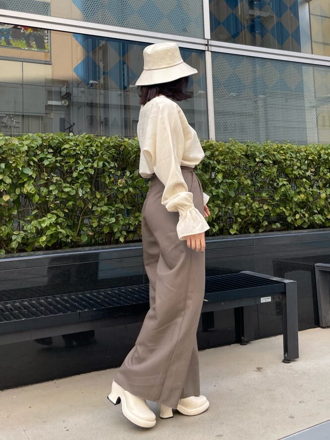 ホワイト系のパンプス、ブラウン系のその他パンツ、ホワイト系のシャツ/ブラウスを着用したレディースの春コーディネートの2枚目の写真