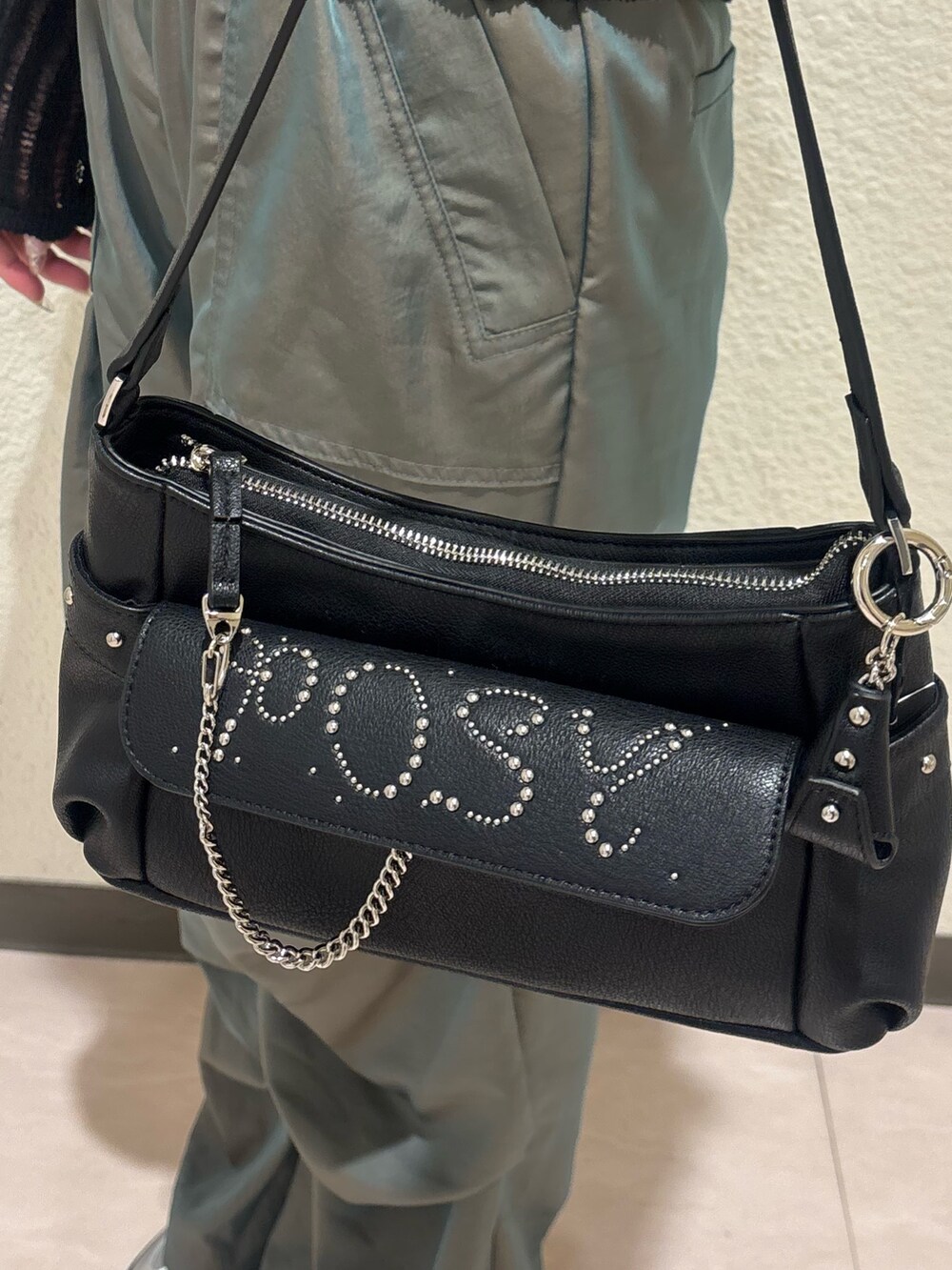 シルバー系のスニーカー、ブラック系のハンドバッグ、ブラック系のニット/セーターを着用したレディースの春コーディネートの7枚目の写真