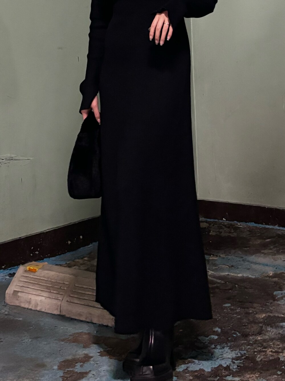 ブラック系のハンドバッグ、ブラック系のワンピース、ブラック系のブーツを着用したレディースの冬コーディネートの4枚目の写真