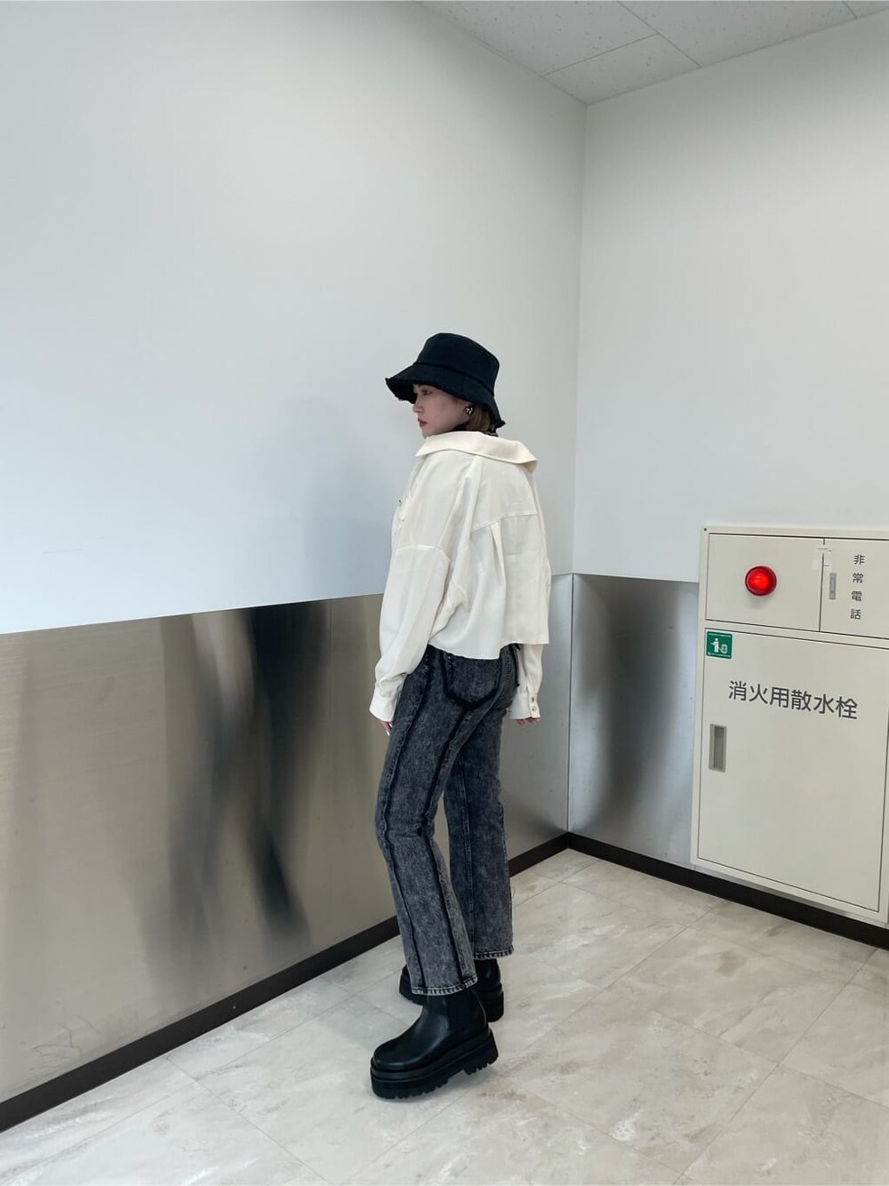 ブラック系のデニムパンツ、ホワイト系のテーラードジャケット、ブラック系のTシャツ/カットソーを着用したレディースの秋コーディネートの2枚目の写真