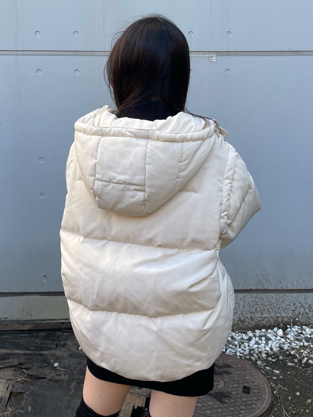 ホワイト系のダウンジャケット/コート、ブラック系のワンピース、ブラック系のブーツを着用したレディースの冬コーディネートの5枚目の写真