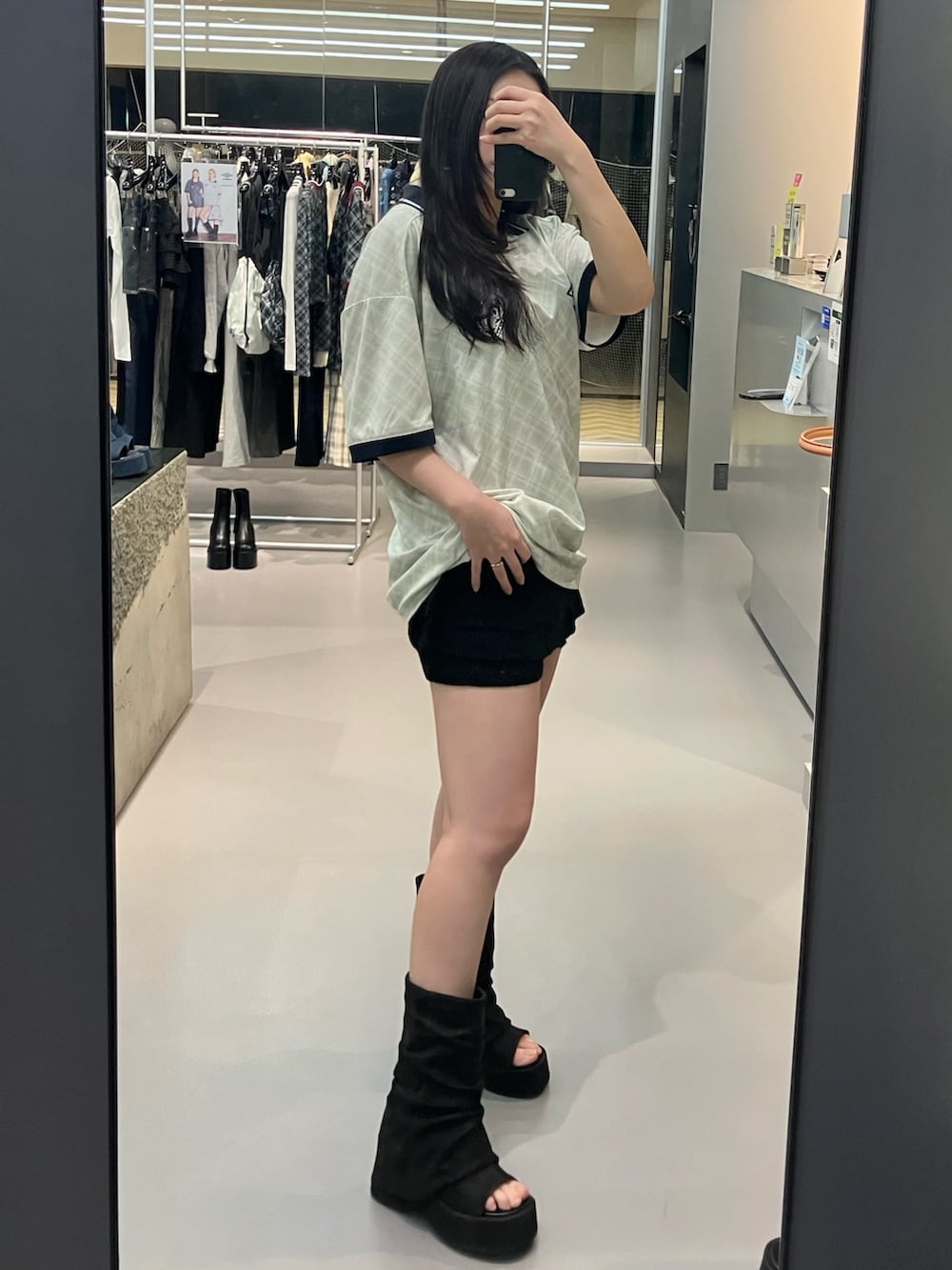 ブラック系のサンダル、グレー系のスカート、ホワイト系のTシャツ/カットソーを着用したレディースの春コーディネートの2枚目の写真