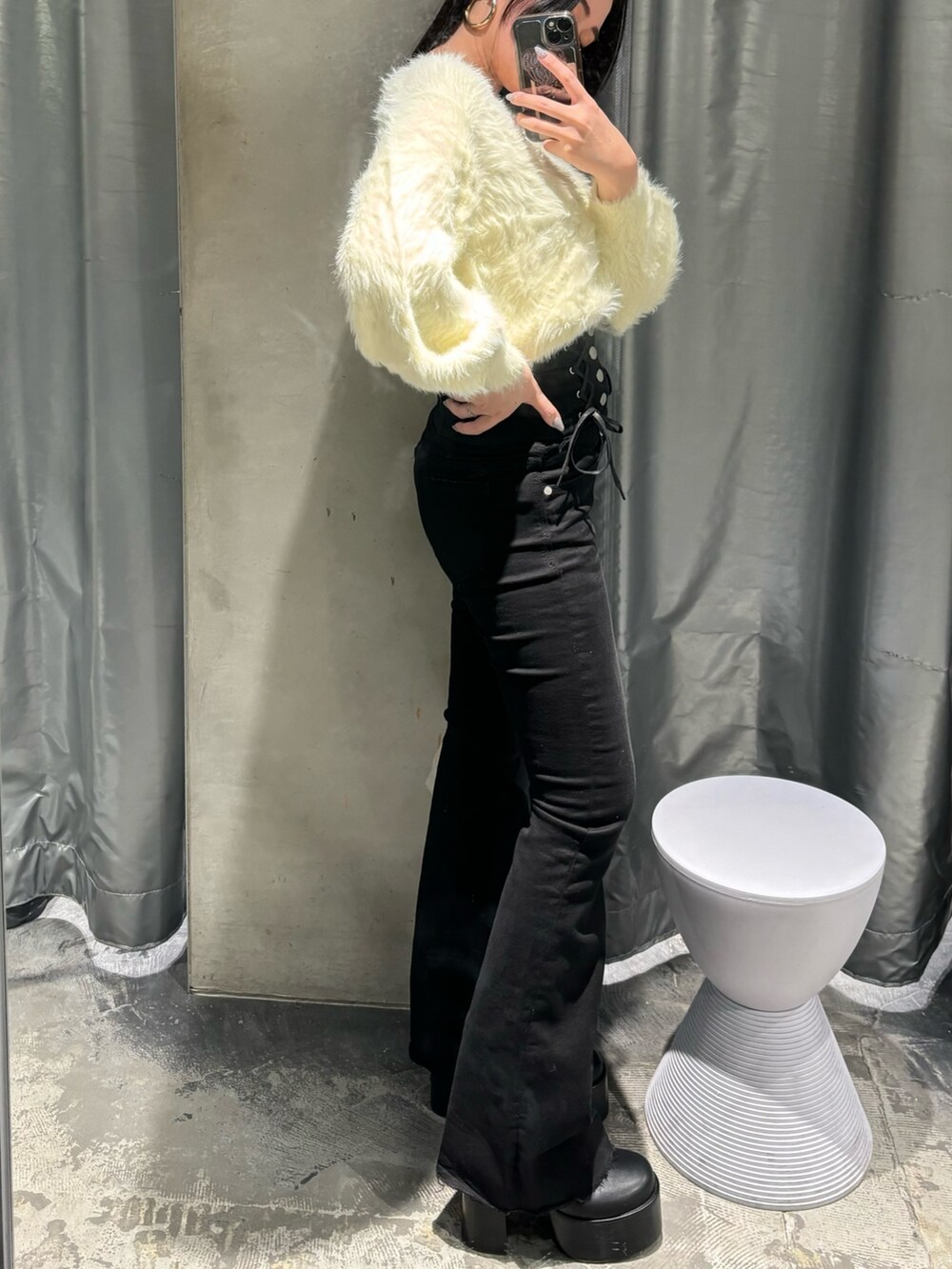 ブラック系のデニムパンツ、ホワイト系のニット/セーター、ブラック系のブーツを着用したレディースの冬コーディネートの2枚目の写真