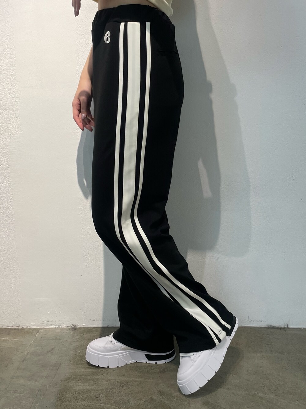 ブラック系のその他パンツ、ホワイト系のTシャツ/カットソー、ブラック系のスニーカーを着用したレディースの夏コーディネートの6枚目の写真