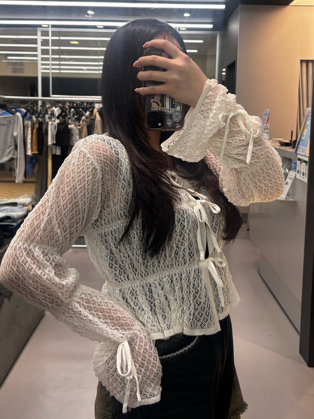 ブラック系のスニーカー、ブルー系のデニムパンツ、ホワイト系のニット/セーターを着用したレディースの春コーディネートの4枚目の写真