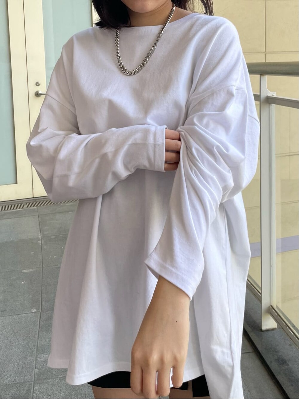 ホワイト系のブーツ、ホワイト系のTシャツ/カットソー、ブラック系のスカートを着用したレディースの春コーディネートの5枚目の写真