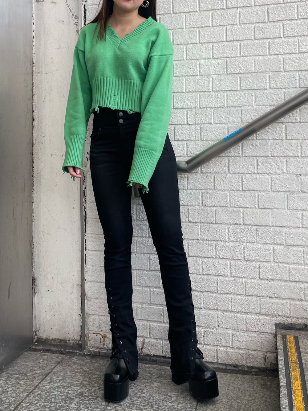 パープル系のチェスターコート、パープル系のニット/セーター、ブラック系のデニムパンツを着用したレディースの冬コーディネートの7枚目の写真