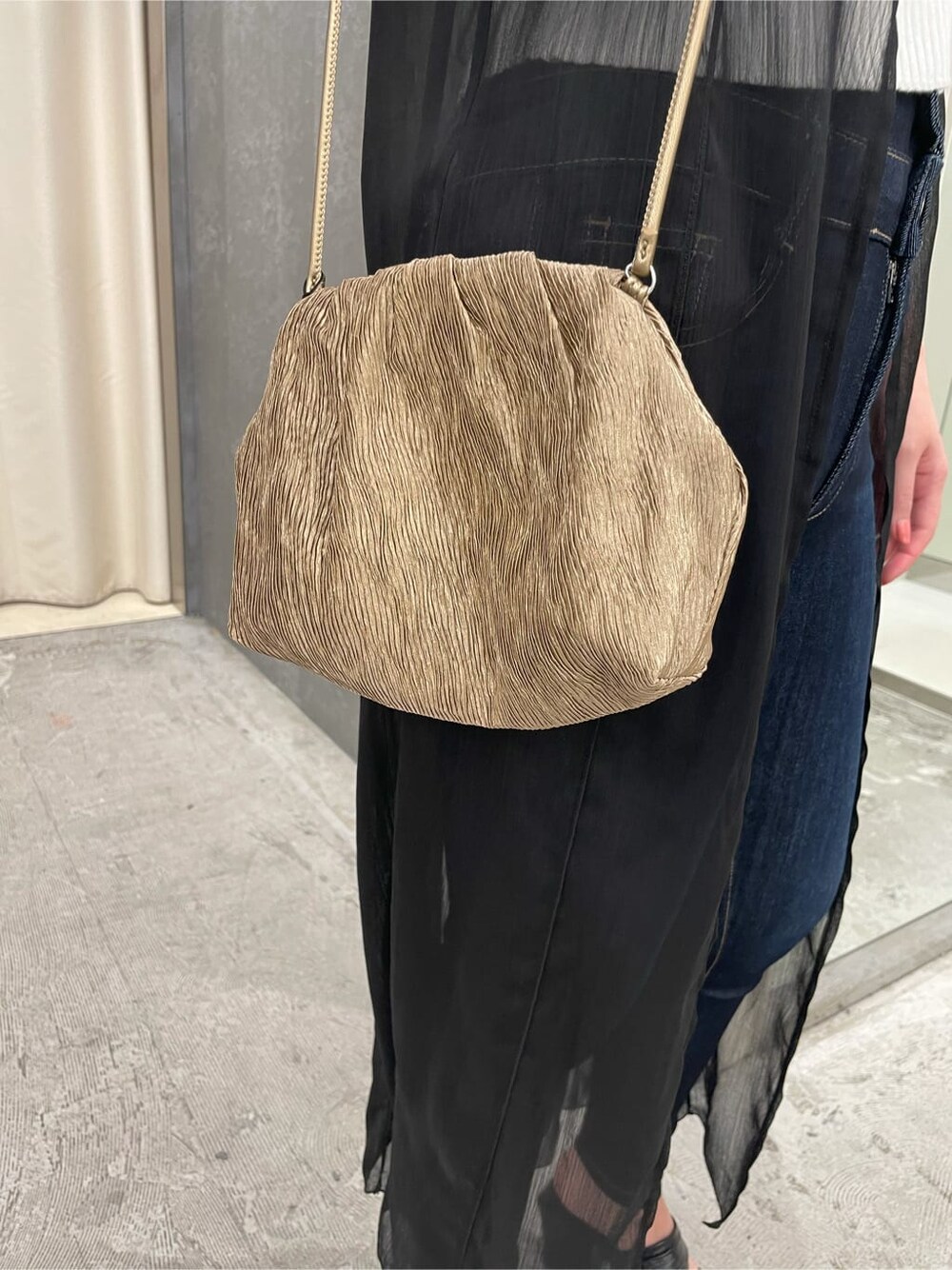 ブラック系のシャツ/ブラウス、ベージュ系のハンドバッグ、ホワイト系のニット/セーターを着用したレディースの夏コーディネートの5枚目の写真