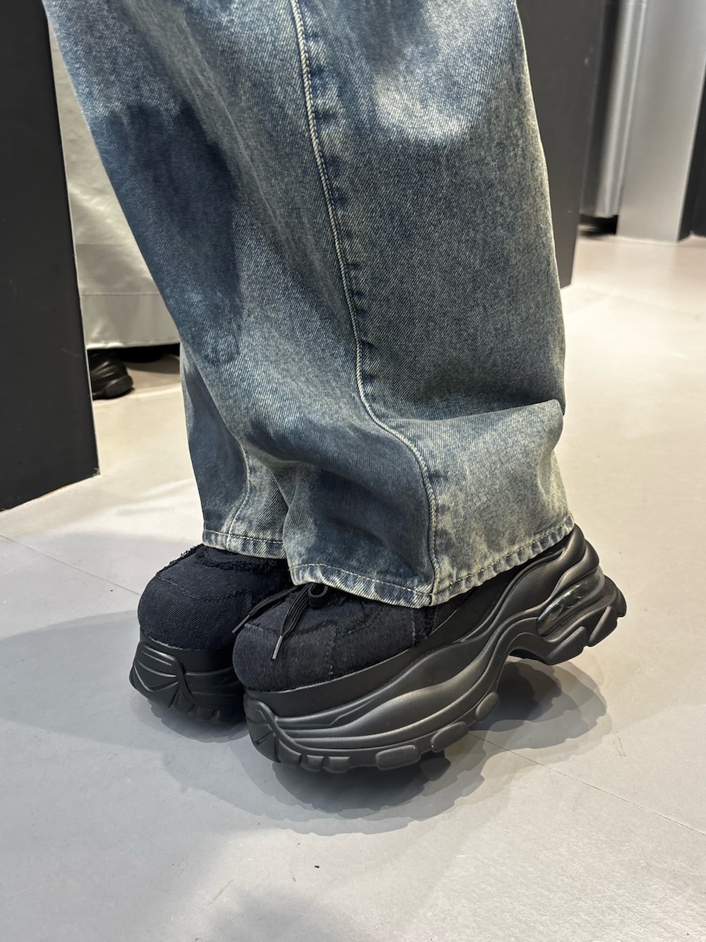ブラック系のスニーカー、ブルー系のデニムパンツ、ブラック系のTシャツ/カットソーを着用したレディースの夏コーディネートの5枚目の写真