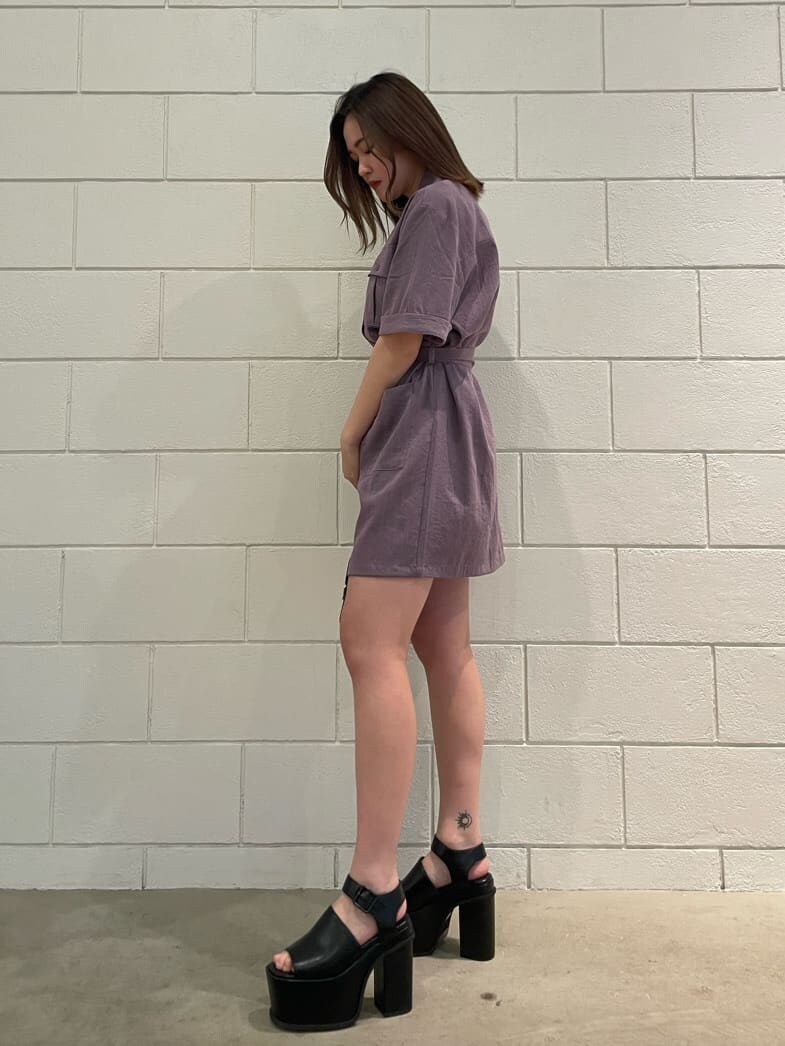 ブラック系のハンドバッグ、ブラック系のサンダル、パープル系のワンピースを着用したレディースの春コーディネートの2枚目の写真