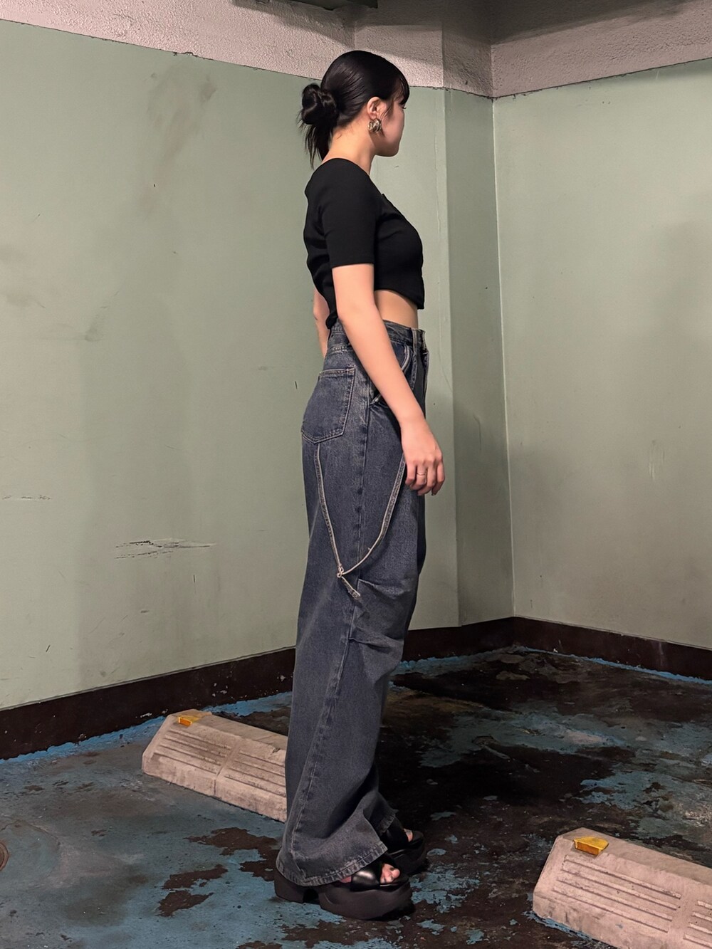 ブルー系のデニムパンツ、ブラック系のTシャツ/カットソー、ブラック系のサンダルを着用したレディースの夏コーディネートの2枚目の写真