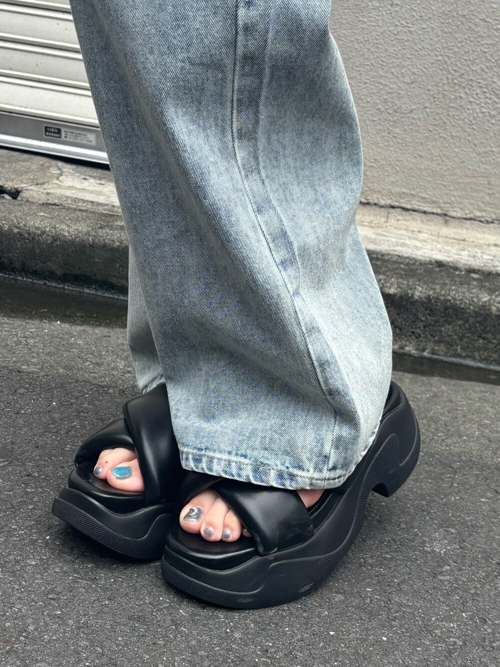 ブラック系のサンダル、ブルー系のデニムパンツ、ブルー系のキャミソールを着用したレディースの夏コーディネートの8枚目の写真