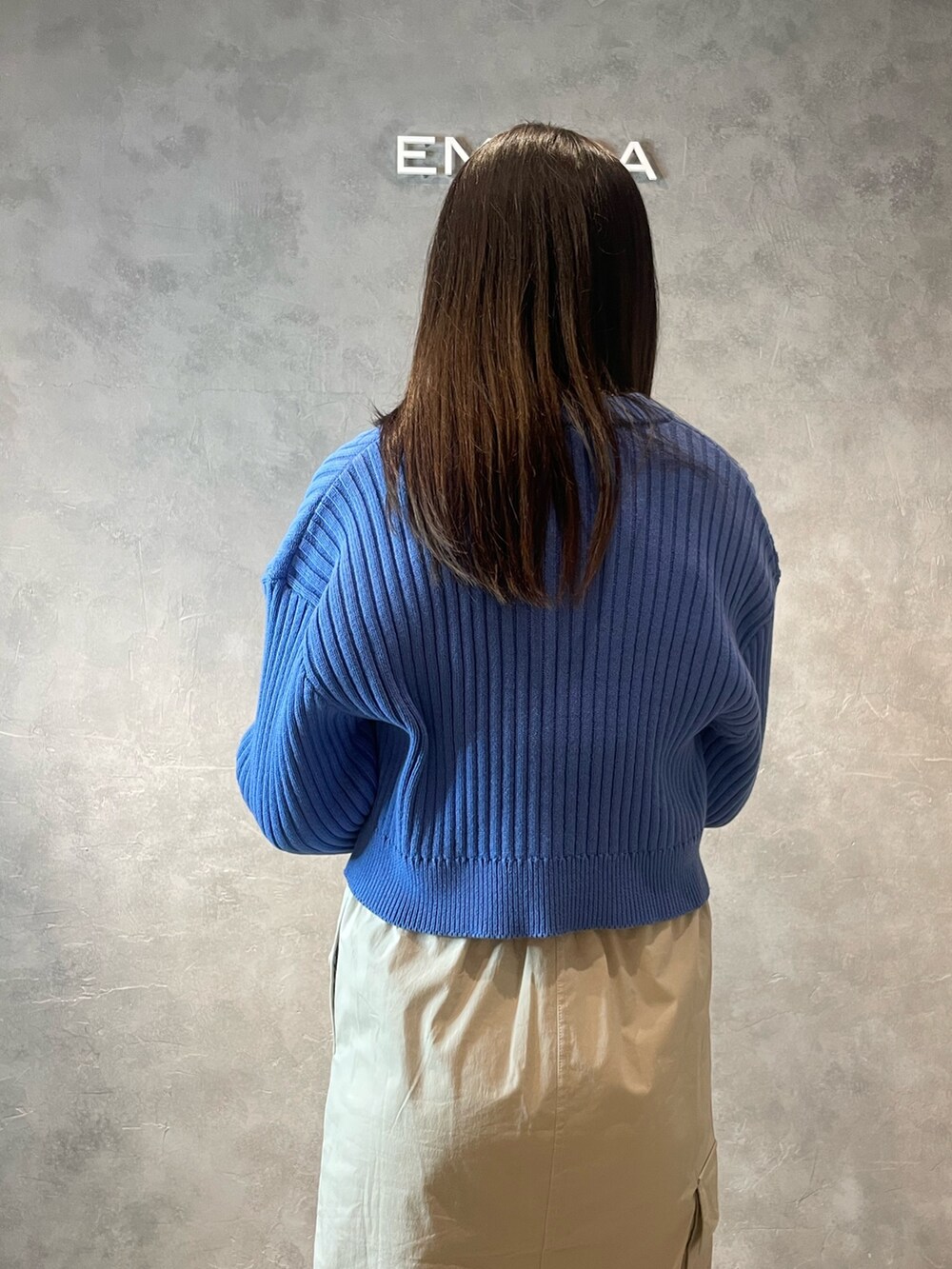 ホワイト系のスカート、ブラック系のブーツ、ブルー系のカーディガン/ボレロを着用したレディースの春コーディネートの6枚目の写真