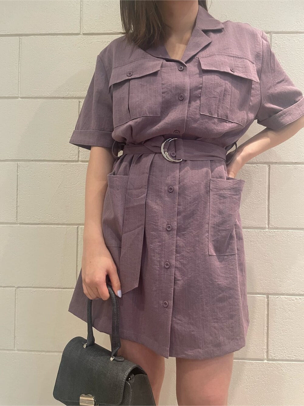 ブラック系のハンドバッグ、ブラック系のサンダル、パープル系のワンピースを着用したレディースの春コーディネートの5枚目の写真