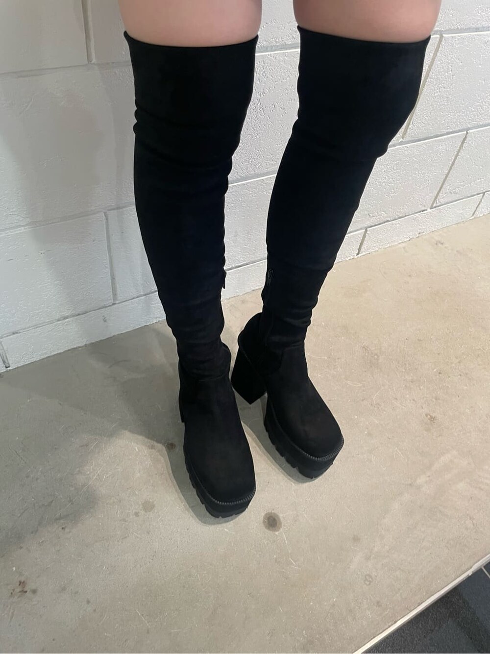 ホワイト系のデニムジャケット、ホワイト系のタンクトップ、ブラック系のブーツを着用したレディースの夏コーディネートの7枚目の写真