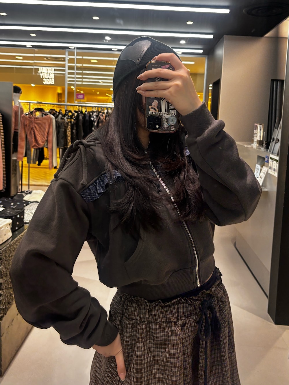 ブラック系のブーツ、ブラック系のスカート、ブラック系のパーカーを着用したレディースの冬コーディネートの3枚目の写真