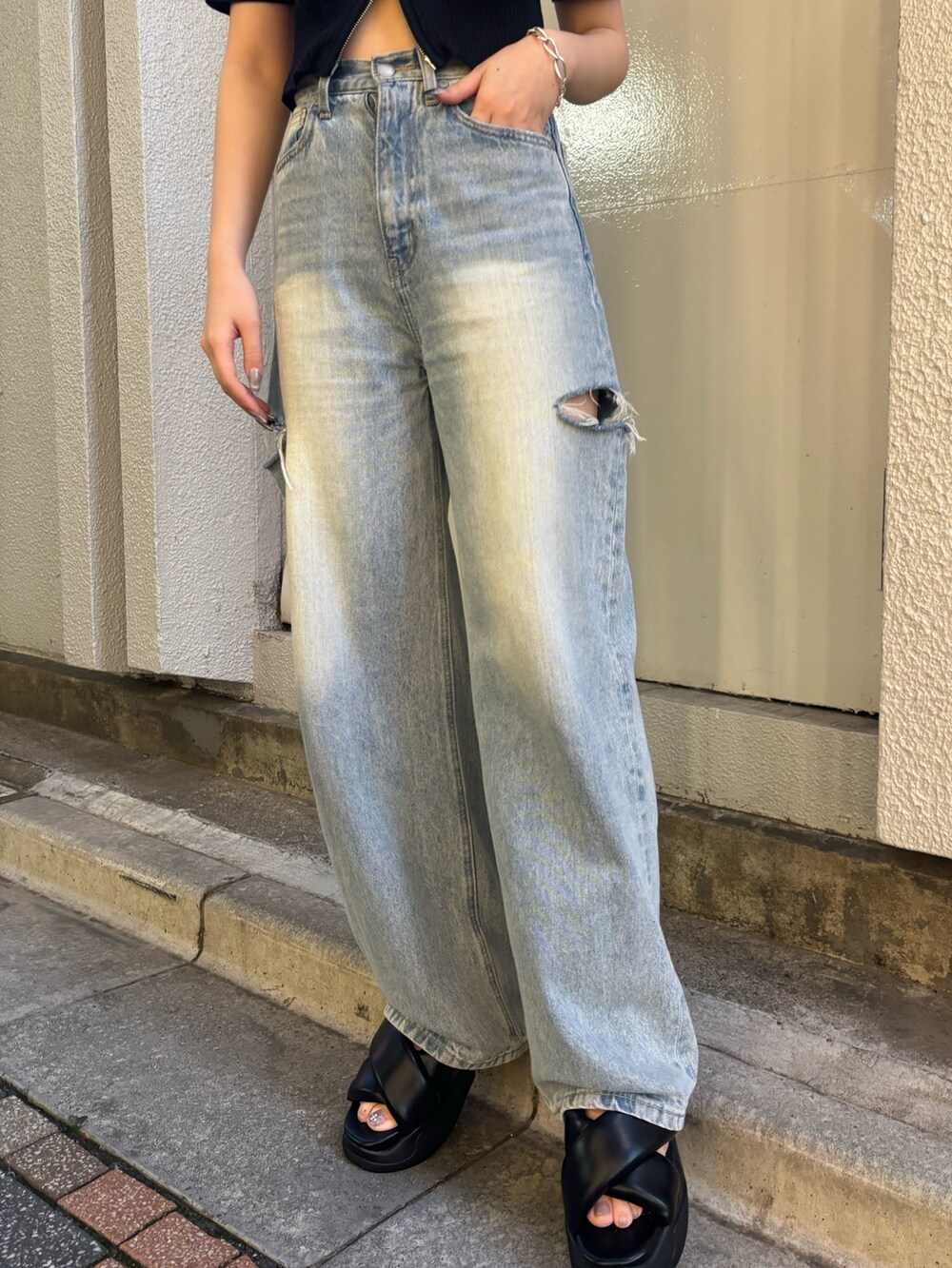 ホワイト系のデニムパンツ、ブラック系のニット/セーター、ブラック系のサンダルを着用したレディースの夏コーディネートの7枚目の写真