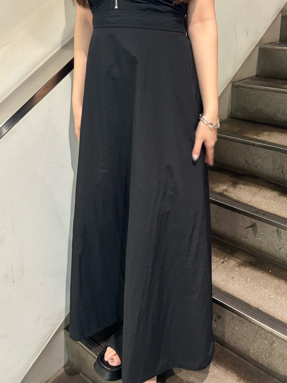 ブラック系のワンピース、ホワイト系のサンダル、ブラック系のタンクトップを着用したレディースの夏コーディネートの6枚目の写真