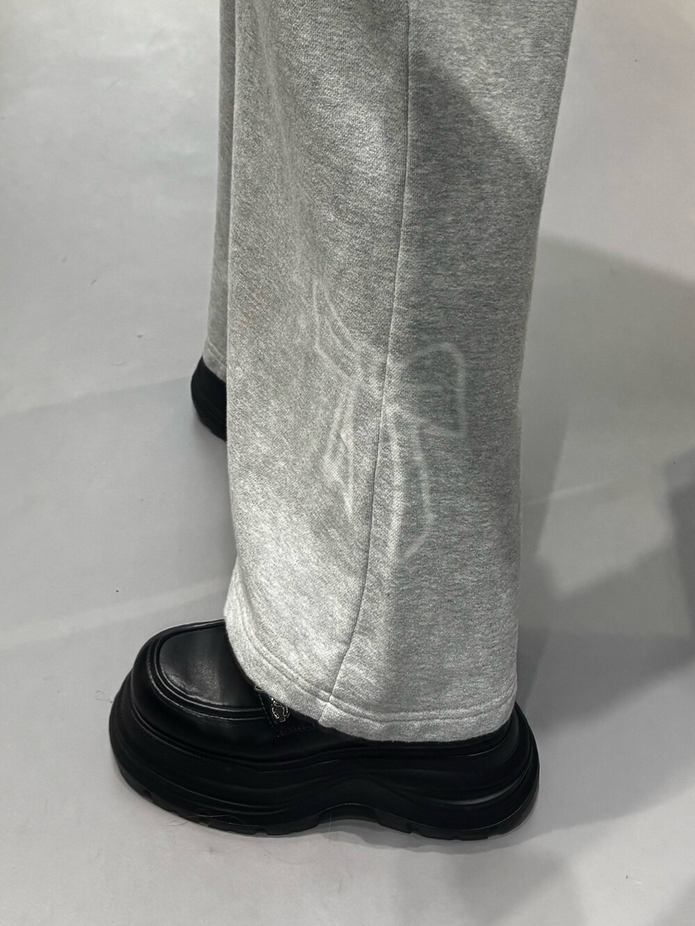 ブラック系のニット/セーター、グレー系のスウェットパンツ、ブラック系のローファーを着用したレディースの冬コーディネートの7枚目の写真