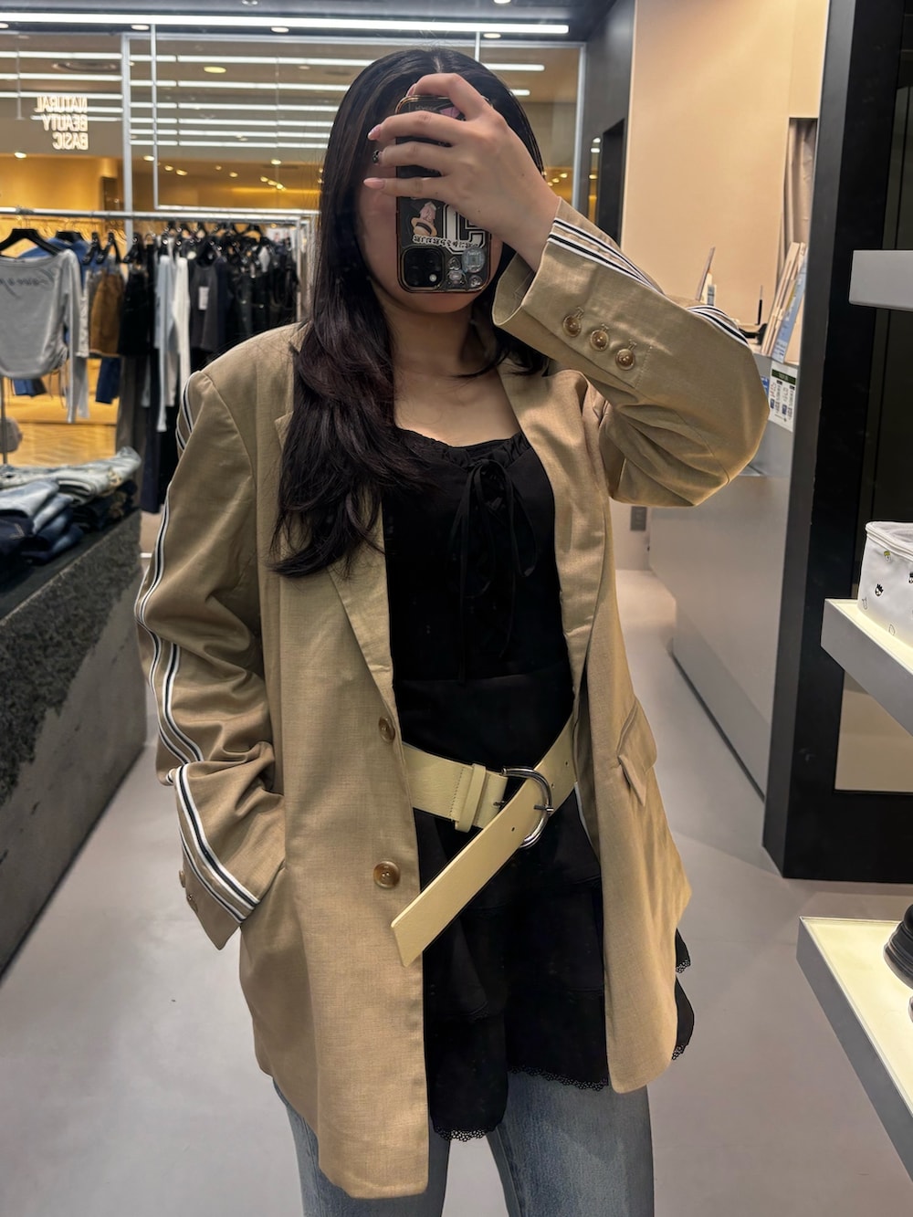 ブラック系のワンピース、グレー系のテーラードジャケット、ブラック系のスニーカーを着用したレディースの春コーディネートの3枚目の写真