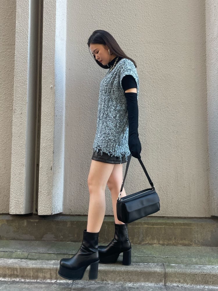 ブルー系のベスト、ブラック系のTシャツ/カットソー、ブラック系のブーツを着用したレディースの秋コーディネートの2枚目の写真