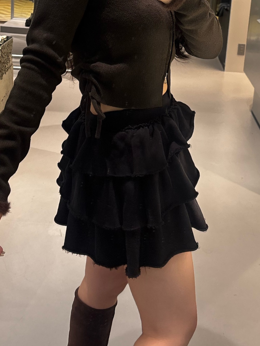 ホワイト系のブーツ、グレー系のスカートを着用したレディースの秋コーディネートの5枚目の写真