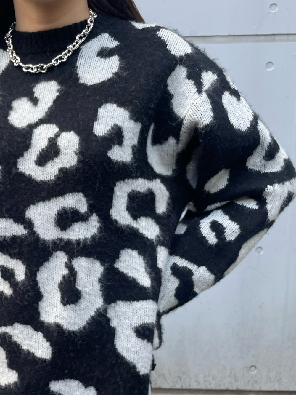 ブラック系のニット/セーター、ブラック系のスカート、ブラック系のブーツを着用したレディースの冬コーディネートの6枚目の写真