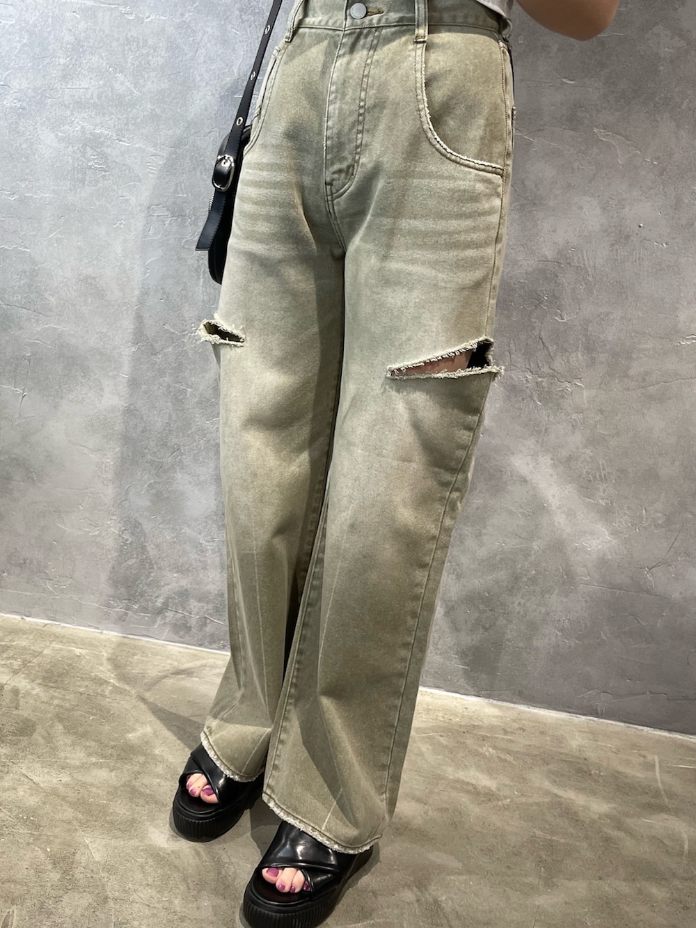 ベージュ系のデニムパンツ、グレー系のTシャツ/カットソー、ブラック系のショルダーバッグを着用したレディースの春コーディネートの7枚目の写真