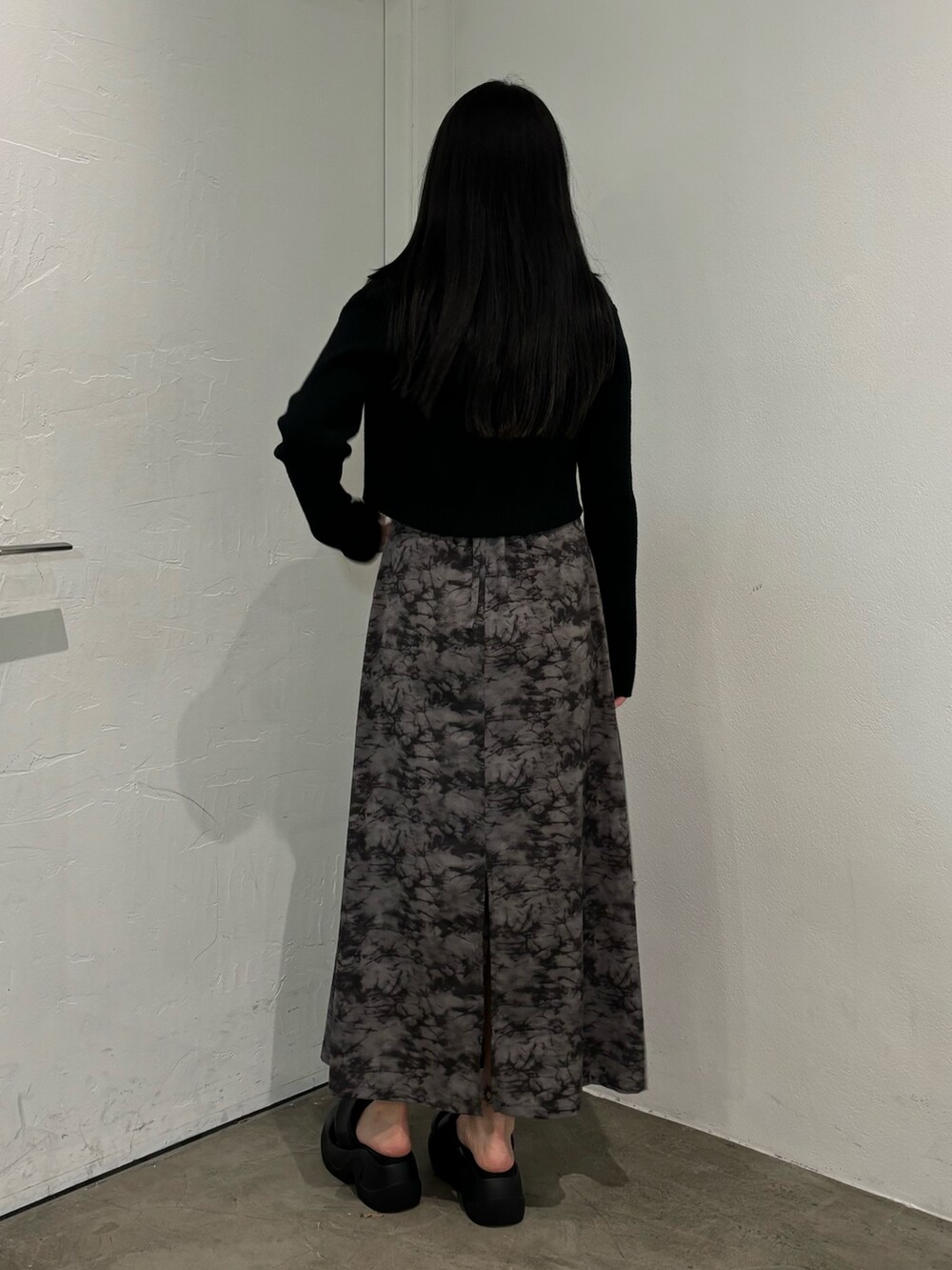 ブラック系のニット/セーター、ブラック系のショルダーバッグを着用したレディースの春コーディネートの3枚目の写真