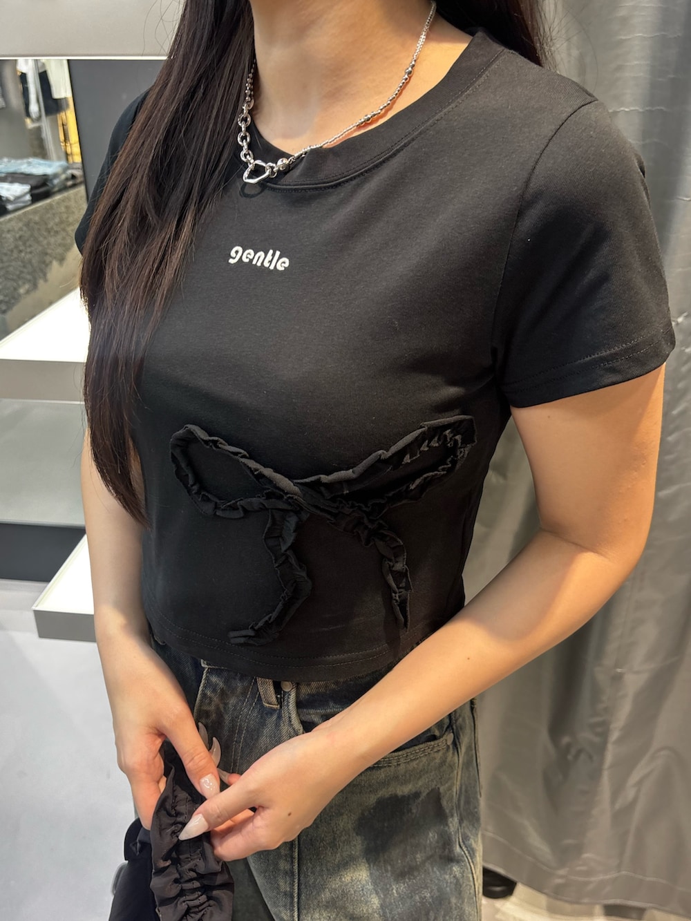 ブラック系のスニーカー、ブルー系のデニムパンツ、ブラック系のTシャツ/カットソーを着用したレディースの夏コーディネートの4枚目の写真