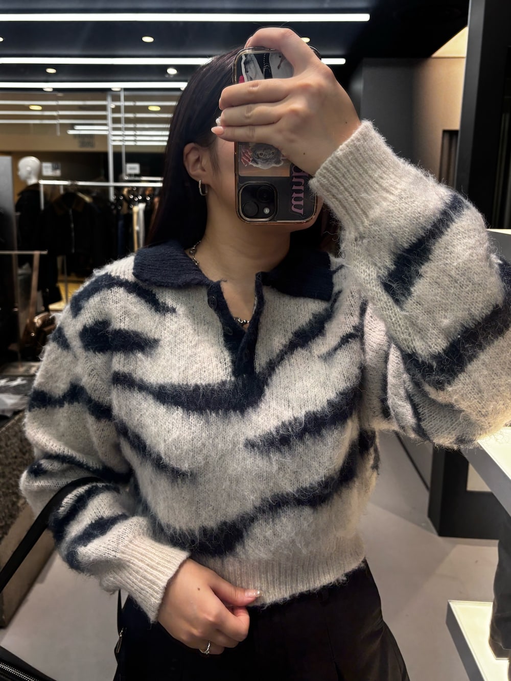 ホワイト系のブーツ、ホワイト系のニット/セーター、ブラック系のスカートを着用したレディースの秋コーディネートの3枚目の写真