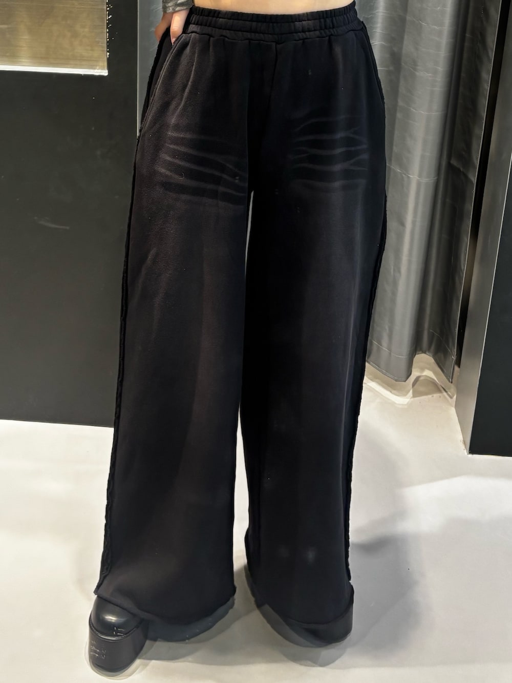 ブラック系のブーツ、ブラック系のスウェットパンツ、グレー系のTシャツ/カットソーを着用したレディースの秋コーディネートの3枚目の写真