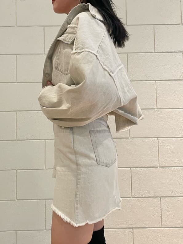 ホワイト系のデニムジャケット、ホワイト系のタンクトップ、ブラック系のブーツを着用したレディースの夏コーディネートの5枚目の写真