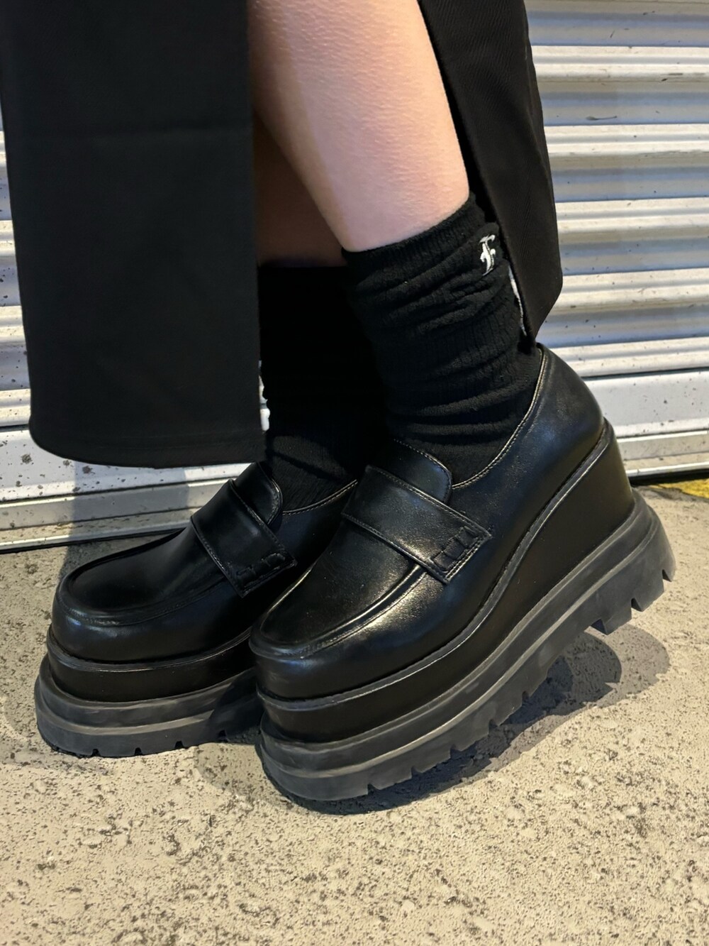 ブラック系のローファー、ブラック系のスカート、ブラック系のニット/セーターを着用したレディースの冬コーディネートの7枚目の写真