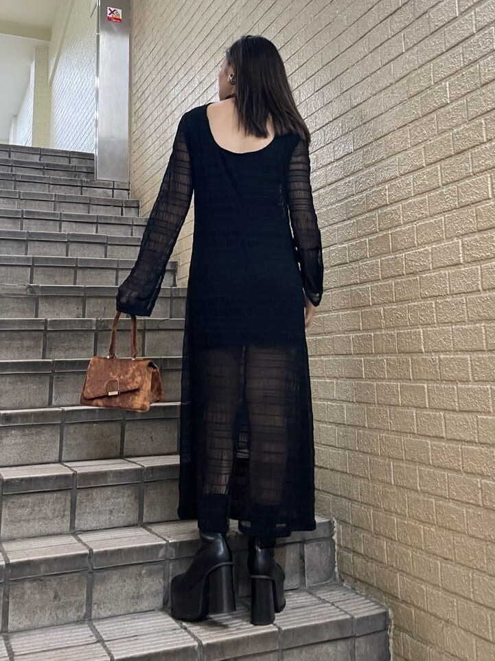 ブラック系のブーツ、ブラック系のワンピース、シルバー系のネックレスを着用したレディースの秋コーディネートの3枚目の写真