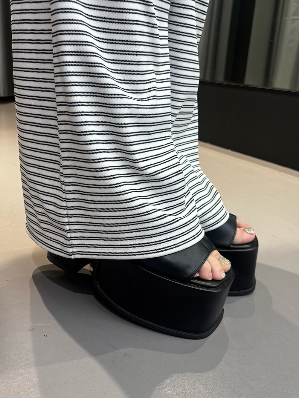 ブラック系のサンダル、ホワイト系のその他パンツ、ホワイト系のTシャツ/カットソーを着用したレディースの夏コーディネートの6枚目の写真