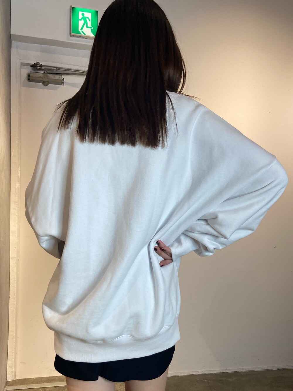 ホワイト系のスウェット、ホワイト系のブーツ、ブラック系のスカートを着用したレディースの冬コーディネートの5枚目の写真