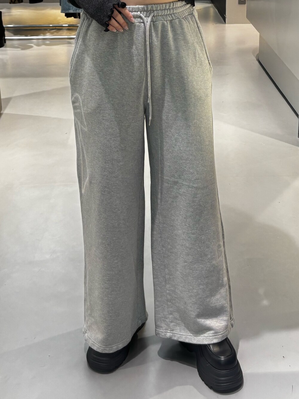 ブラック系のニット/セーター、グレー系のスウェットパンツ、ブラック系のローファーを着用したレディースの冬コーディネートの5枚目の写真