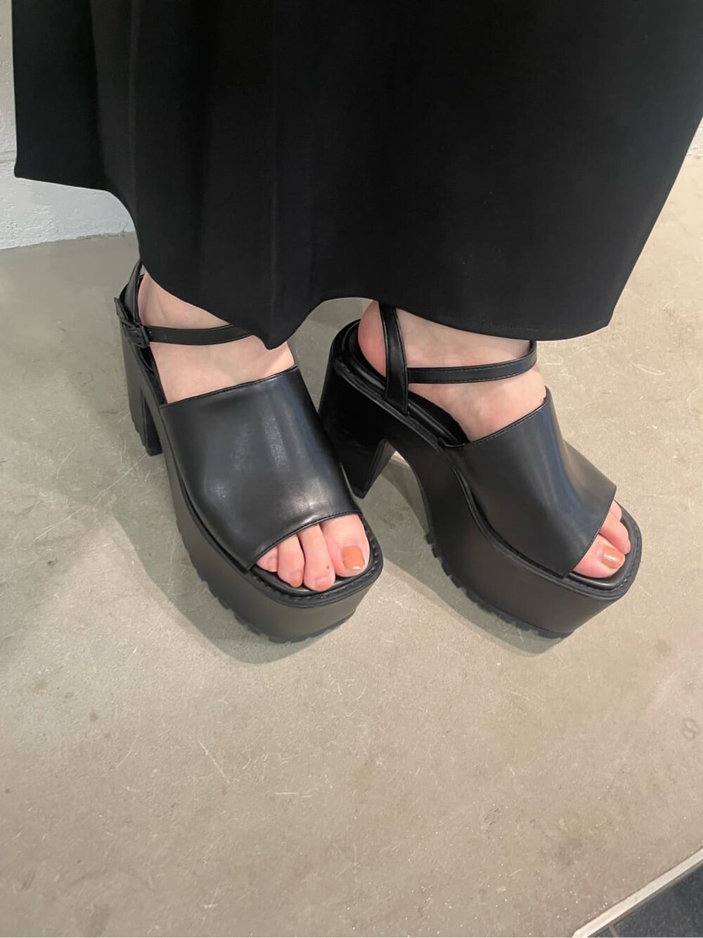 ブラック系のスカート、ブラック系のサンダル、ブルー系のTシャツ/カットソーを着用したレディースの夏コーディネートの7枚目の写真