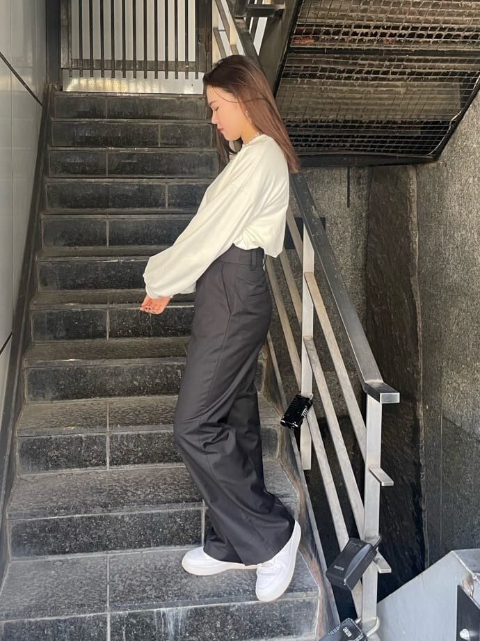 ブラック系のスラックス、ホワイト系のスウェット、シルバー系のネックレスを着用したレディースの秋コーディネートの2枚目の写真