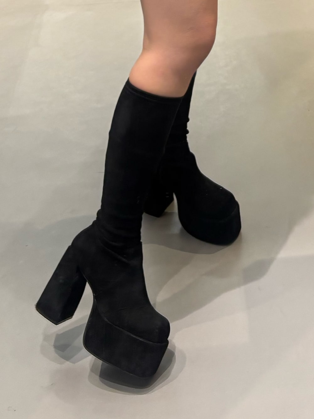 ブラック系のスカート、ブラック系のブーツ、ブラウン系のブルゾンを着用したレディースの秋コーディネートの5枚目の写真