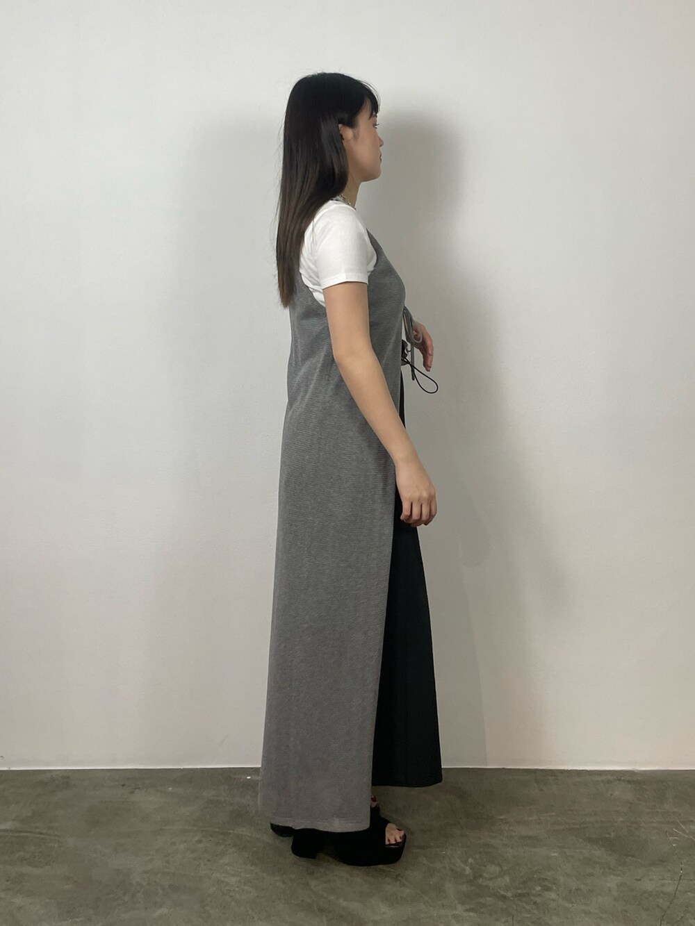 ブラック系のスカート、ホワイト系のTシャツ/カットソー、ブラック系のサンダルを着用したレディースの夏コーディネートの2枚目の写真