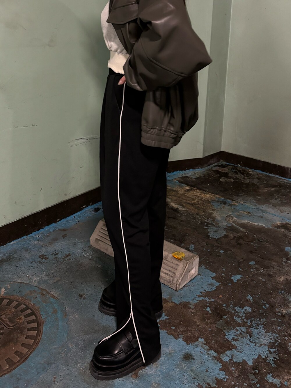 ブラック系のスラックス、ブラック系のローファー、グレー系のブルゾンを着用したレディースの冬コーディネートの7枚目の写真