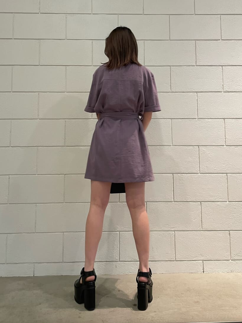 ブラック系のハンドバッグ、ブラック系のサンダル、パープル系のワンピースを着用したレディースの春コーディネートの3枚目の写真